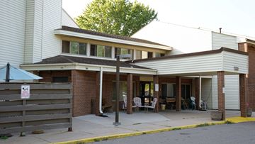 St Cloud apartment for rent - A building with a covered entrance and a sign on a fence.