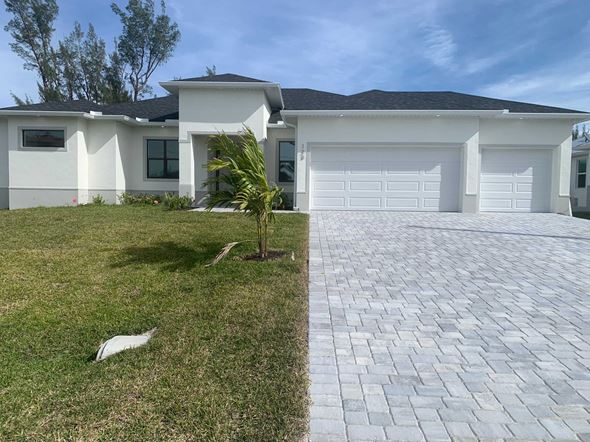 Cape Coral house for rent - A white house with a grey roof and a brick driveway.