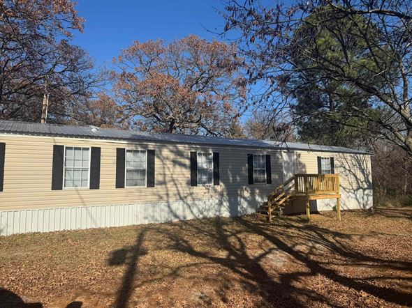 Norman house for rent - A house with a porch and a tree in front.