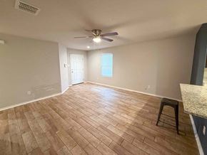 San Antonio house for rent - A room with a ceiling fan and wooden flooring.