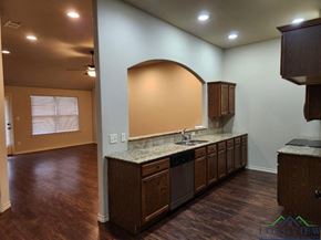 Longview apartment for rent - A kitchen with wooden cabinets and a granite countertop.