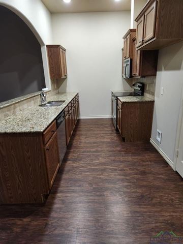 Longview apartment for rent - A kitchen with wooden cabinets and a granite countertop.