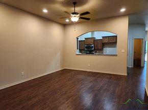 Longview apartment for rent - A room with a ceiling fan and wooden flooring.