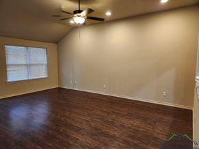 Longview apartment for rent - A room with a ceiling fan and wooden flooring.