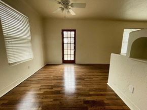 Las Cruces house for rent - A room with wooden floors and a ceiling fan.