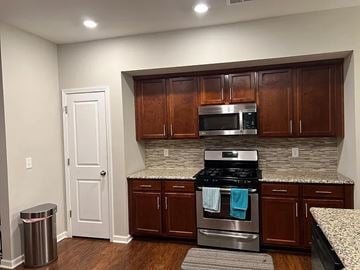 Morrisville house for rent - A kitchen with brown cabinets and a stove top oven.