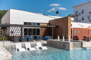 Hampton apartment for rent - A pool area with a water feature and lounge chairs.