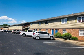 Monroe apartment for rent - A parking lot with cars and a building in the background.