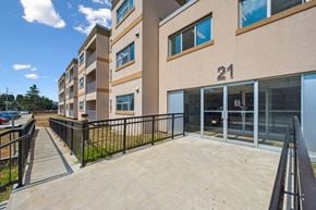 Kitchener apartment for rent - A building with the number 21 on it has a black fence around it.