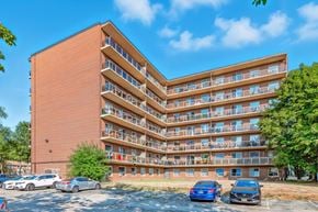 Burlington apartment for rent - A large apartment building with a parking lot in front.