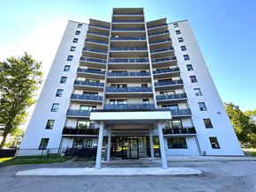Mississauga apartment for rent - A white apartment building with balconies and a black gate in front.