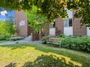 Barrie apartment for rent - A building with a sign on it and a bench in front of it.