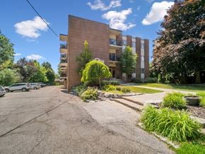 Barrie apartment for rent - A parking lot in front of a brick apartment building.