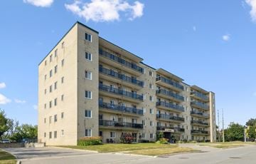Barrie apartment for rent - A large concrete building with balconies on the upper floors.