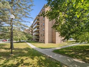 Barrie apartment for rent - A tall building with a grassy area in front of it.
