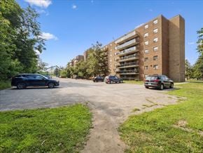 Barrie apartment for rent - A black car is parked on the left side of a driveway with a building in the background.
