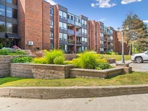 Barrie apartment for rent - A brick building with a green lawn in front.