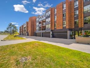 Barrie apartment for rent - A large brick building with a grassy area in front.