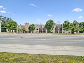 Barrie apartment for rent - A street view of a residential area with apartment buildings and trees.