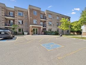 Barrie apartment for rent - A parking lot in front of a multi-story apartment building with a handicap parking space.