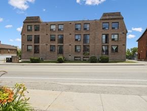 Orillia apartment for rent - A large brick building with many windows sits on a street corner.