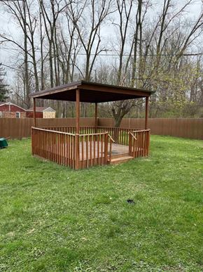 Lima house for rent - A wooden gazebo with a brown roof is situated in a grassy backyard.