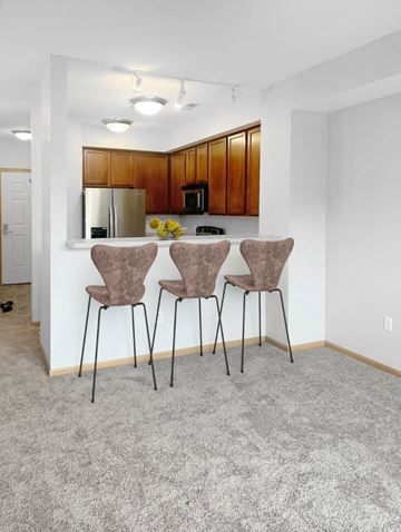 Burnsville house for rent - Three brown chairs are placed in a row in a white room.
