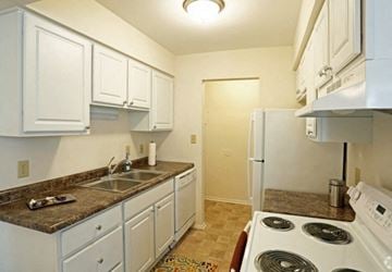 Monroe apartment for rent - A kitchen with white cabinets and a granite countertop.