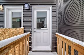 Edmonton apartment for rent - A white door is on the right side of a grey house.