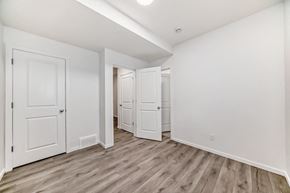 Edmonton apartment for rent - A room with white walls and wooden flooring with three doors.