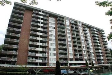North Vancouver apartment for rent - A large apartment building with balconies and a parking lot in front.