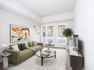 Washington apartment for rent - A living room with a green couch, a coffee table, and a painting on the wall.