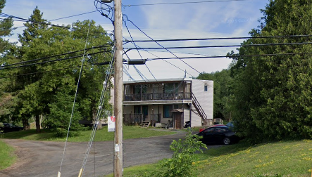 Ottawa apartment for rent - A building with a balcony and a car parked in front.
