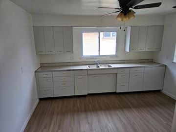 Clairton house for rent - A kitchen with white cabinets and a ceiling fan.