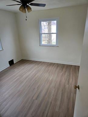 Clairton house for rent - A room with a ceiling fan and a window with a view of trees.