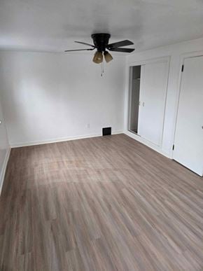 Clairton house for rent - A room with a ceiling fan and wood flooring.