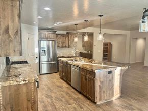 Washington house for rent - A kitchen with a marble countertop and wooden cabinets.