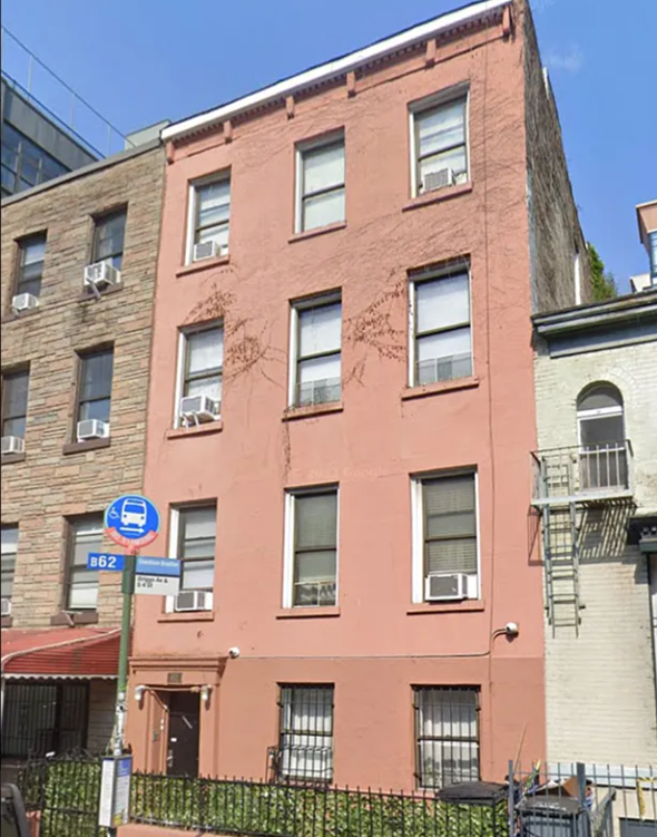 Williamsburg apartment for rent - A red building with a blue sign on the corner.