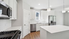 Blaine house for rent - A modern kitchen with white cabinets and a large island.