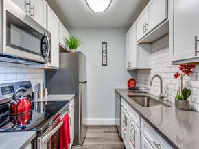 Killeen apartment for rent - A kitchen with white cabinets and a black fridge.