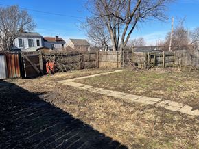 Louisville apartment for rent - A backyard with a fence and a small patch of grass.