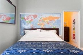 Santa Barbara house for rent - A bedroom with a world map on the wall and a bed with a blue comforter.