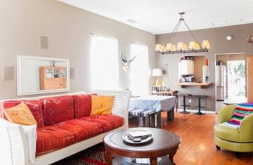 Santa Barbara house for rent - A living room with a red couch and a green armchair.