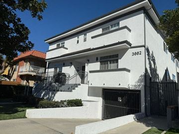 Los Angeles apartment for rent - A white two-story house with black iron railings on the balconies.