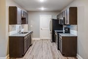 Melbourne apartment for rent - A kitchen with dark brown cabinets and a black refrigerator at Mode at Melbourne, LLC Apartments, Florida, 32901