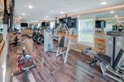 Melbourne apartment for rent - A gym with a variety of equipment including a stationary bike, a leg press machine, and a cable machine at Mode at Melbourne, LLC Apartments, Melbourne, 32901