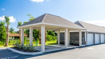 A building with a covered parking area in front.