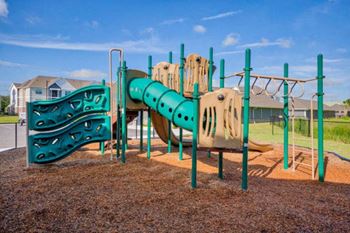A playground with a green and yellow slide.