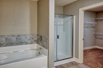 A bathroom with a white tub and a glass shower door.