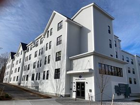 Old Orchard Beach apartment for rent - A white building with a black door and windows on the side.